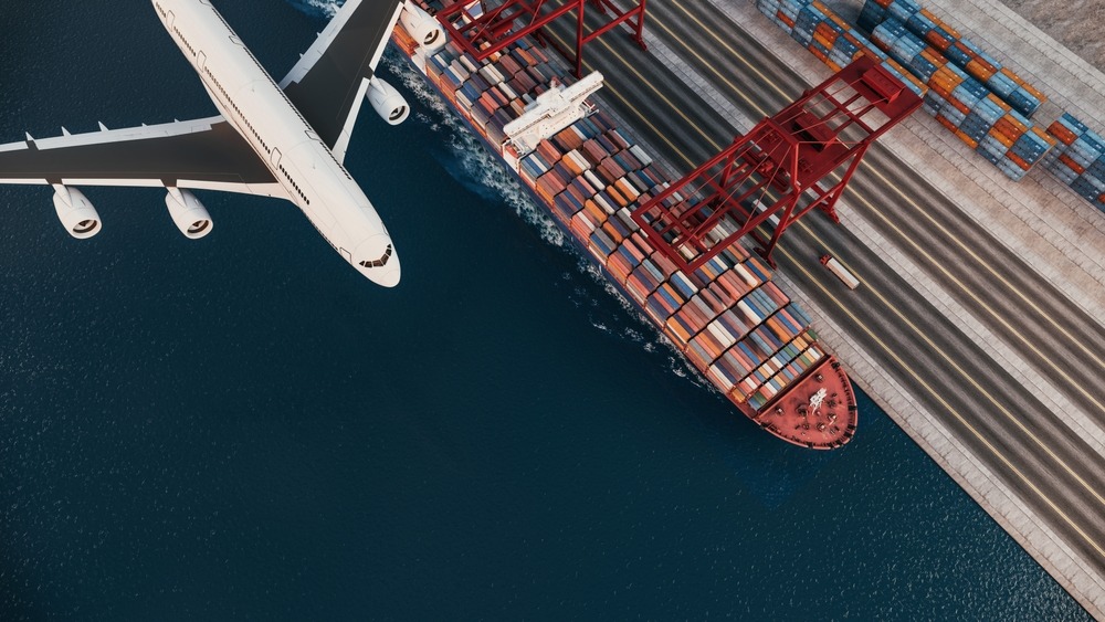 A,Cargo,Ship,At,The,Port,With,A,Flying,Airplane,
